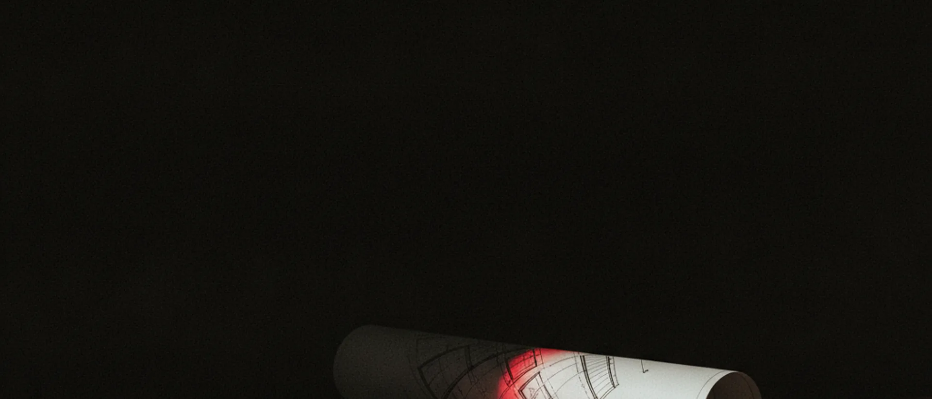 Planta de imóvel e documento sobre mesa escura, iluminados por uma faixa estreita de luz vermelha